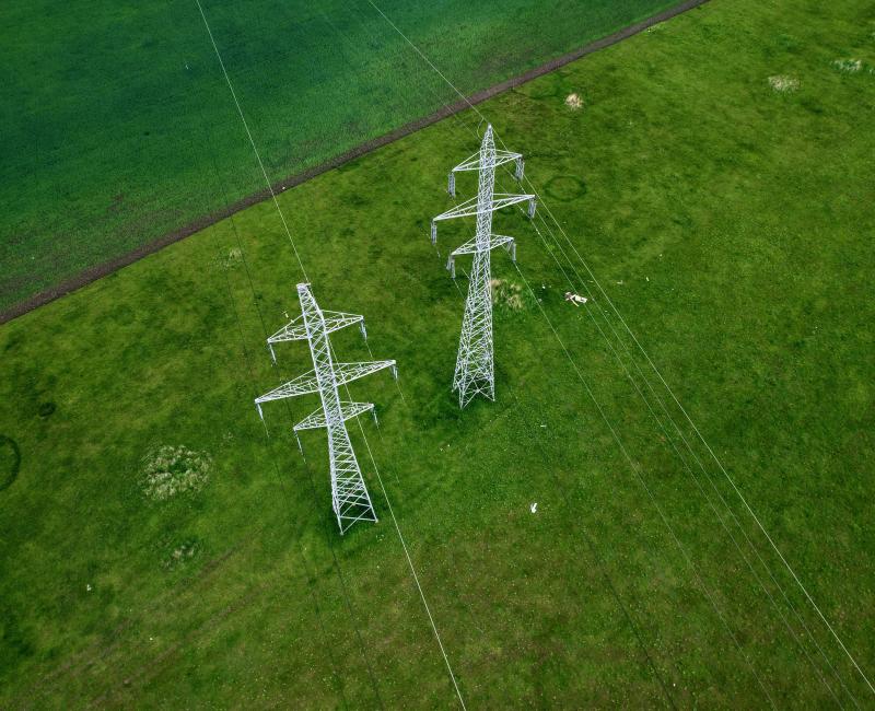 Electricity pylons on a green field